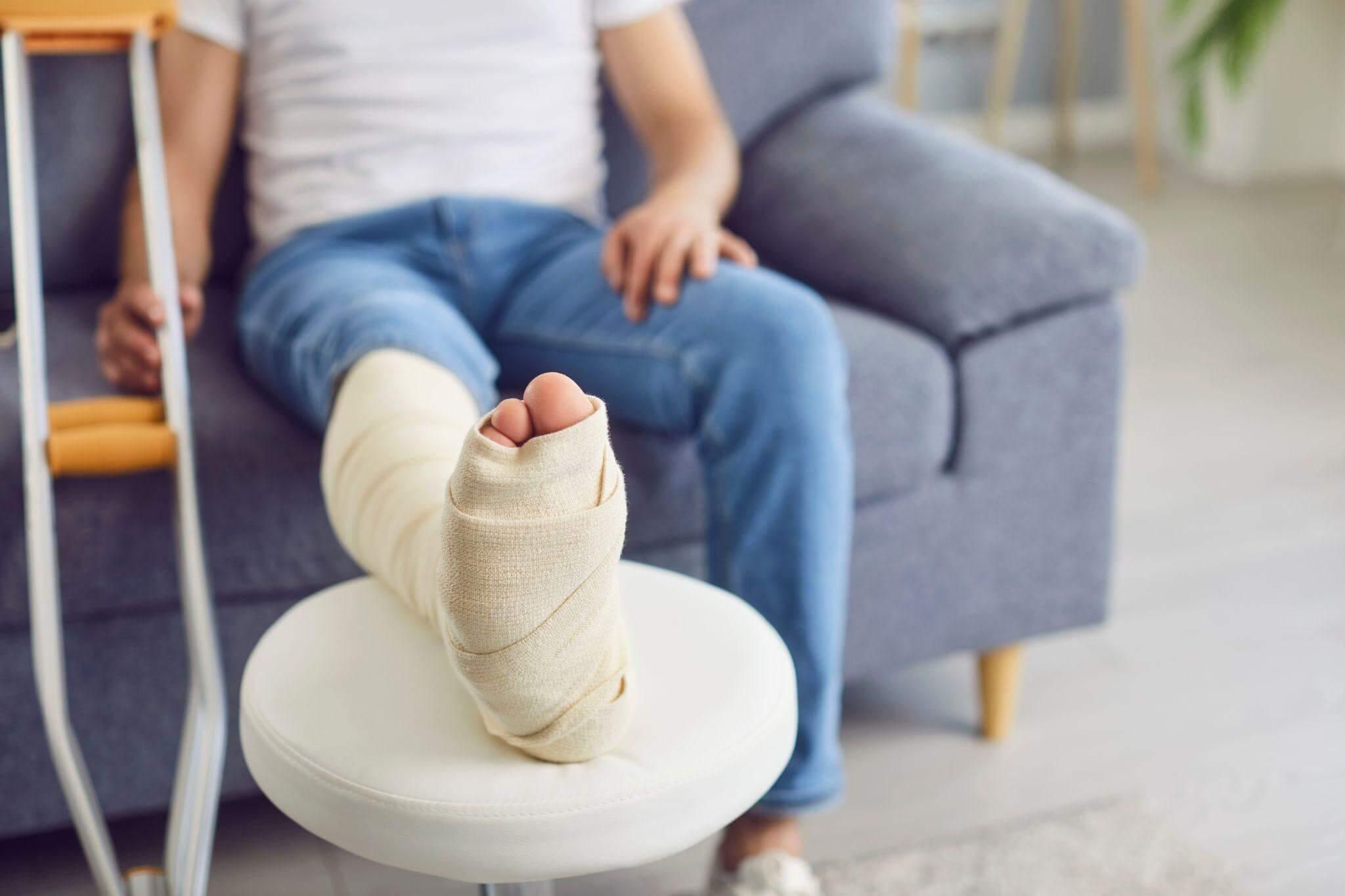 a person with a cast on their foot sitting on a couch