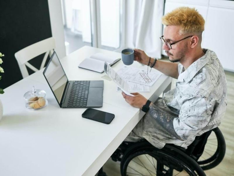 Man in a wheelchair holding a cup of coffee