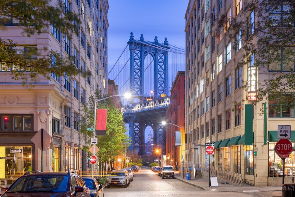 View of the Manhattan Bridge framed between buildings in DUMBO, Brooklyn, New York, at dusk