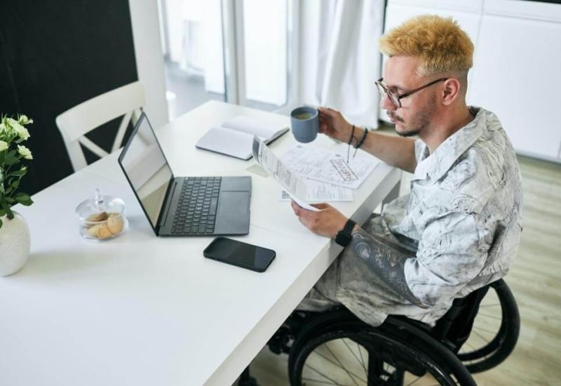 Man in a wheelchair holding a cup of coffee