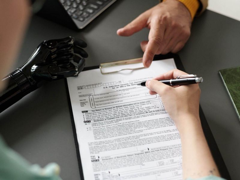 a person sitting at a desk writing on a piece of paper