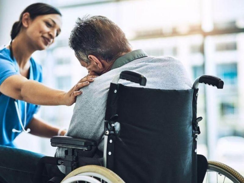 Nurse assisting man in wheelchair