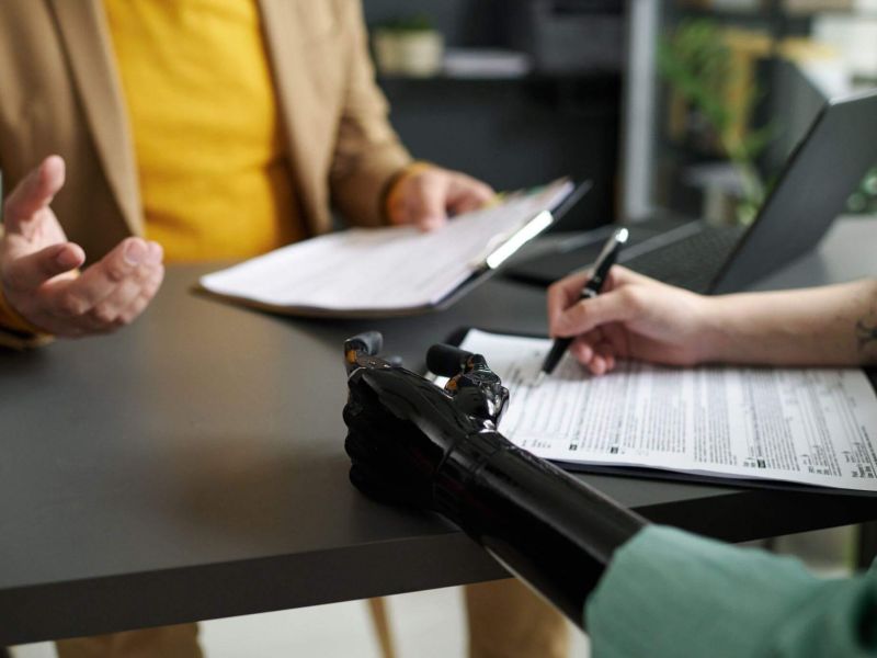 a couple of people sitting at a table with papers
