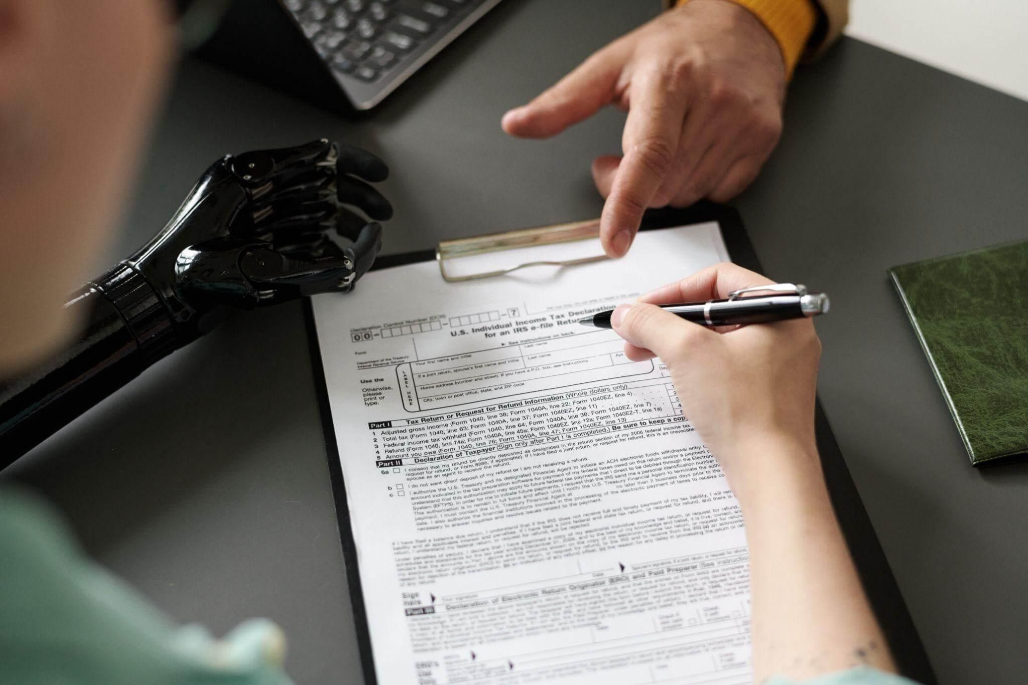 a person sitting at a desk writing on a piece of paper