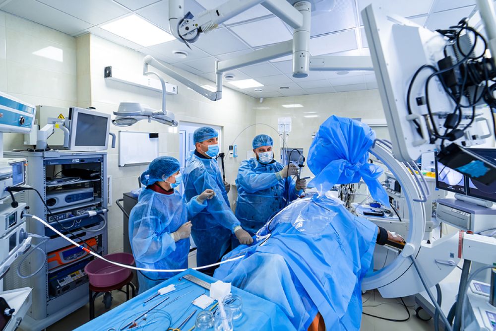 Medical team performing surgery in a modern, high-tech operating room environment.