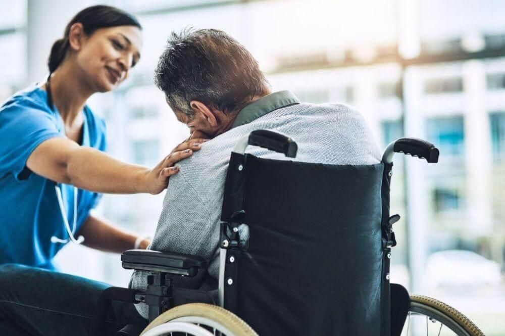Nurse assisting man in wheelchair