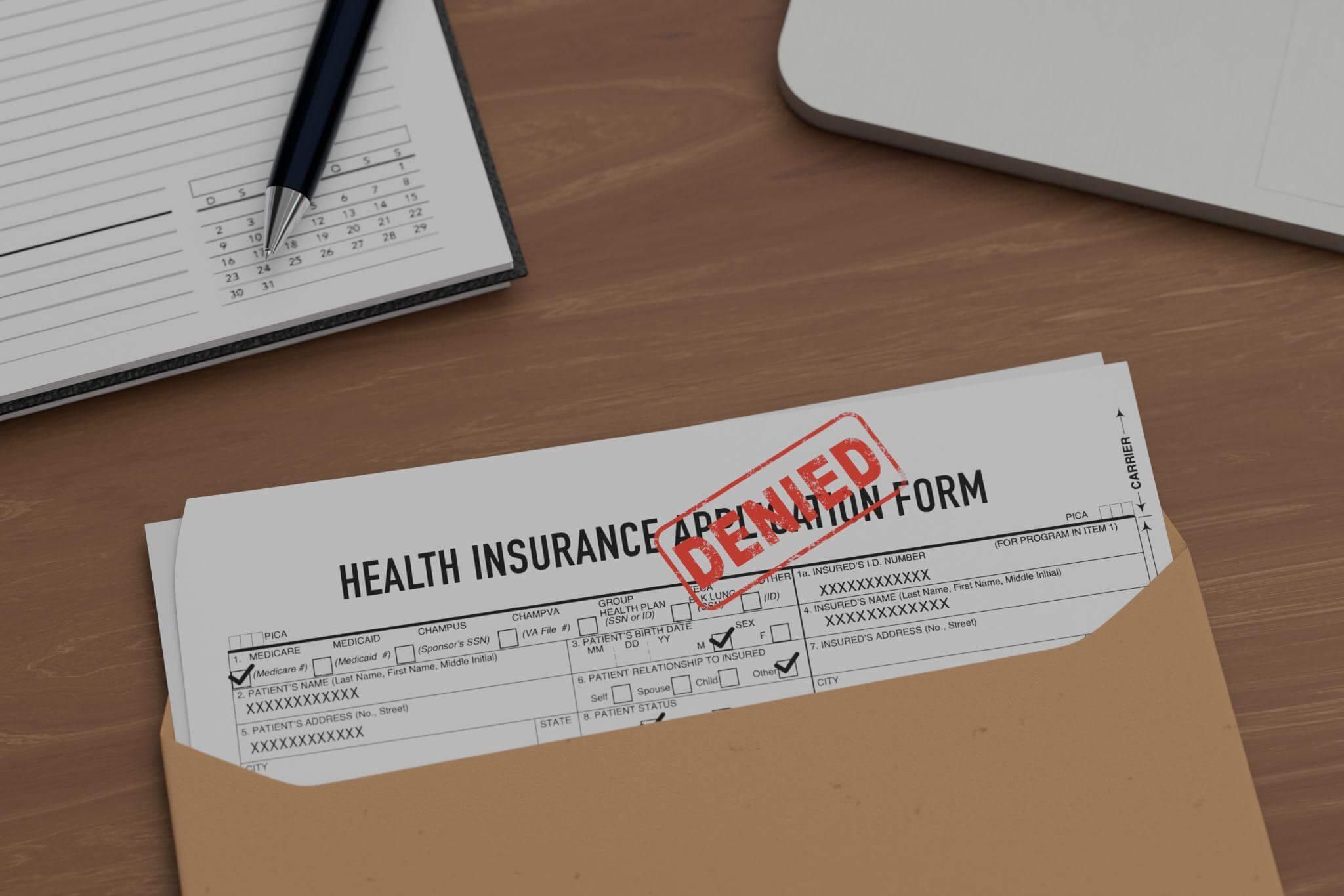 a health insurance form on a desk with a pen