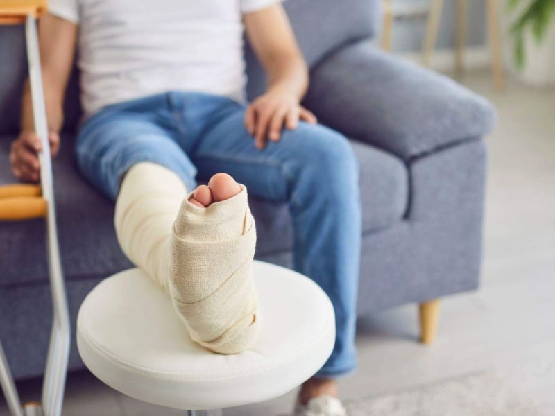 a person with a cast on their foot sitting on a couch