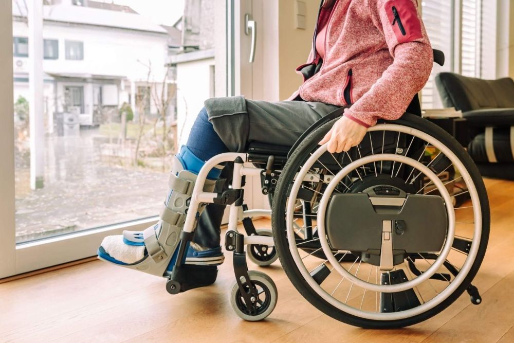 a woman in a wheel chair looking out a window