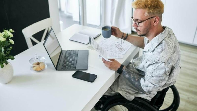 Man in a wheelchair holding a cup of coffee