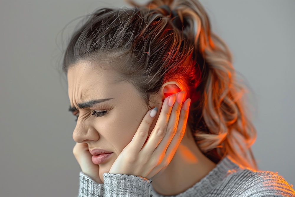 Woman suffering from painful earache, holding her ear in discomfort.