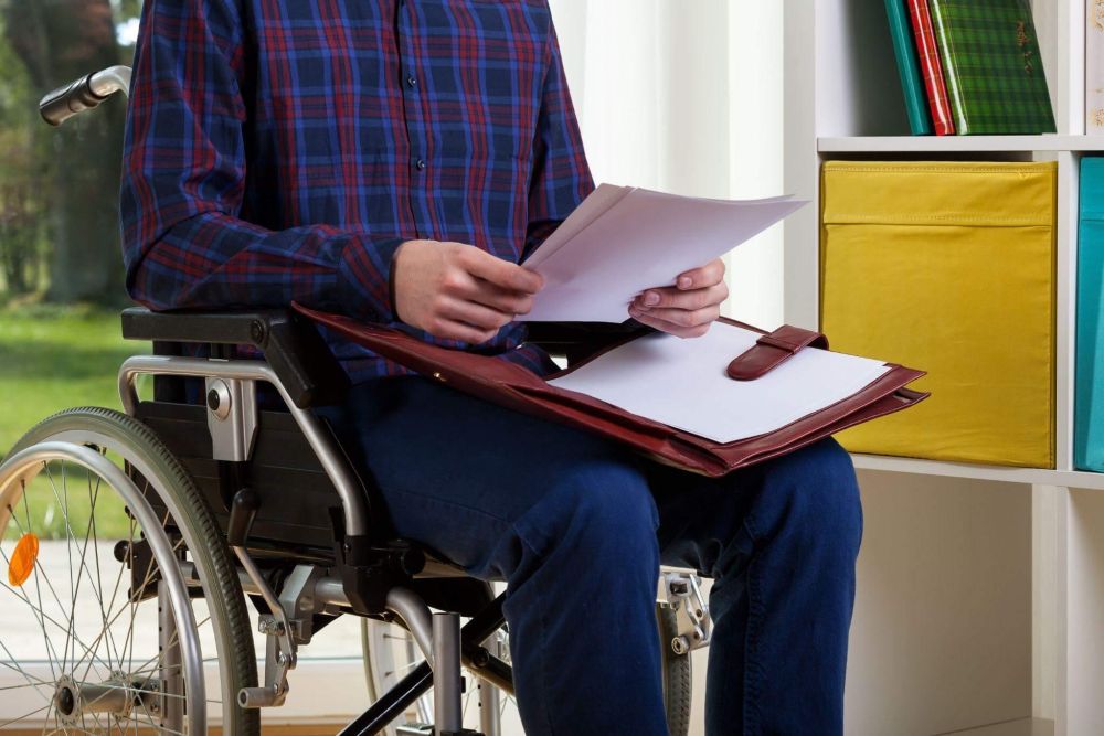 a man in a wheel chair holding a binder