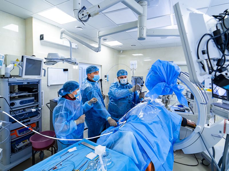 Medical team performing surgery in a modern, high-tech operating room environment.