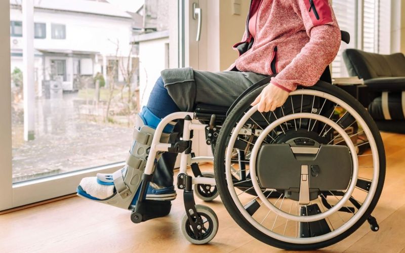 a woman in a wheel chair looking out a window