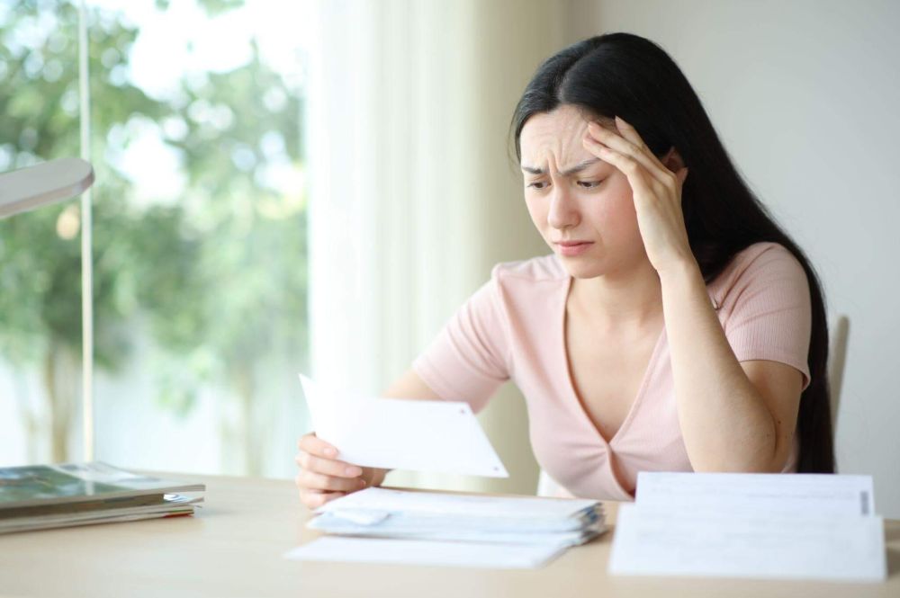 Woman stressed at desk over insurance claim