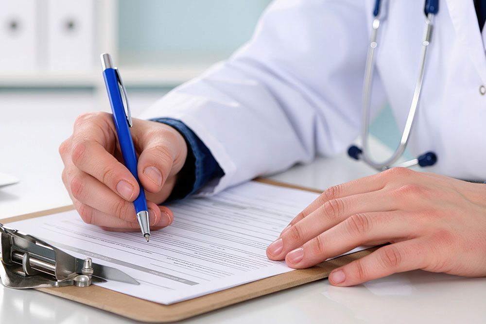 Doctor writing notes on a clipboard with a blue pen, wearing a white coat, close-up view of hands.