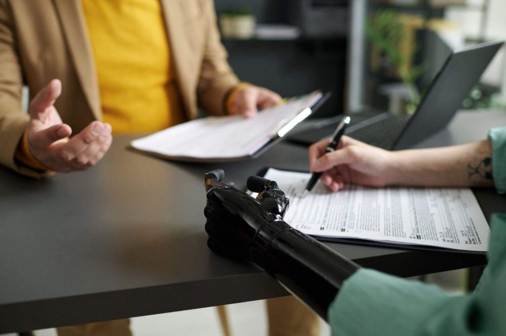 a couple of people sitting at a table with papers