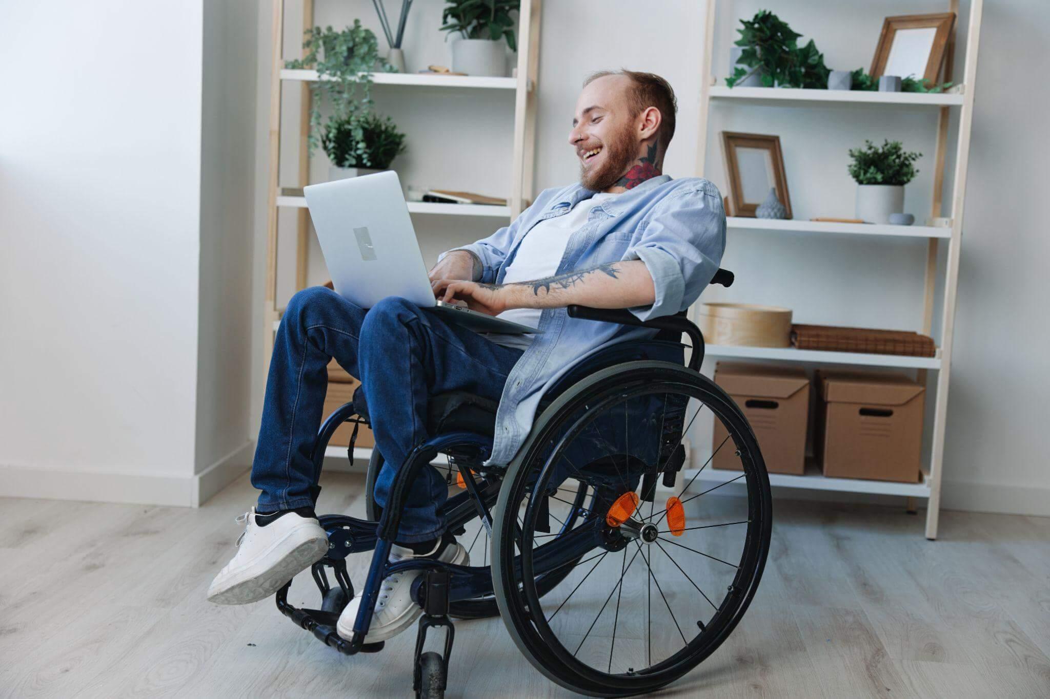 a man in a wheel chair using a laptop