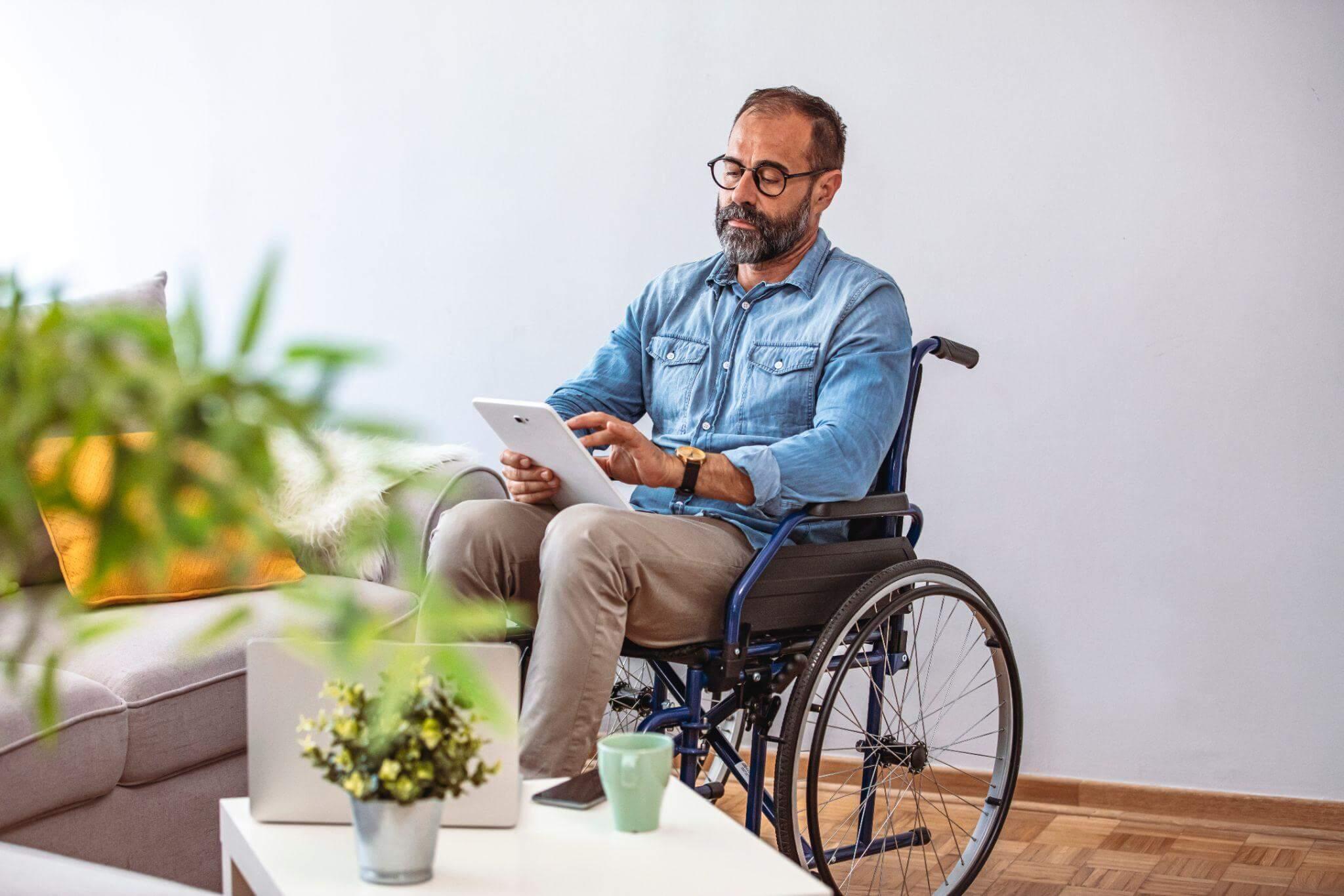 a man in a wheel chair using a tablet