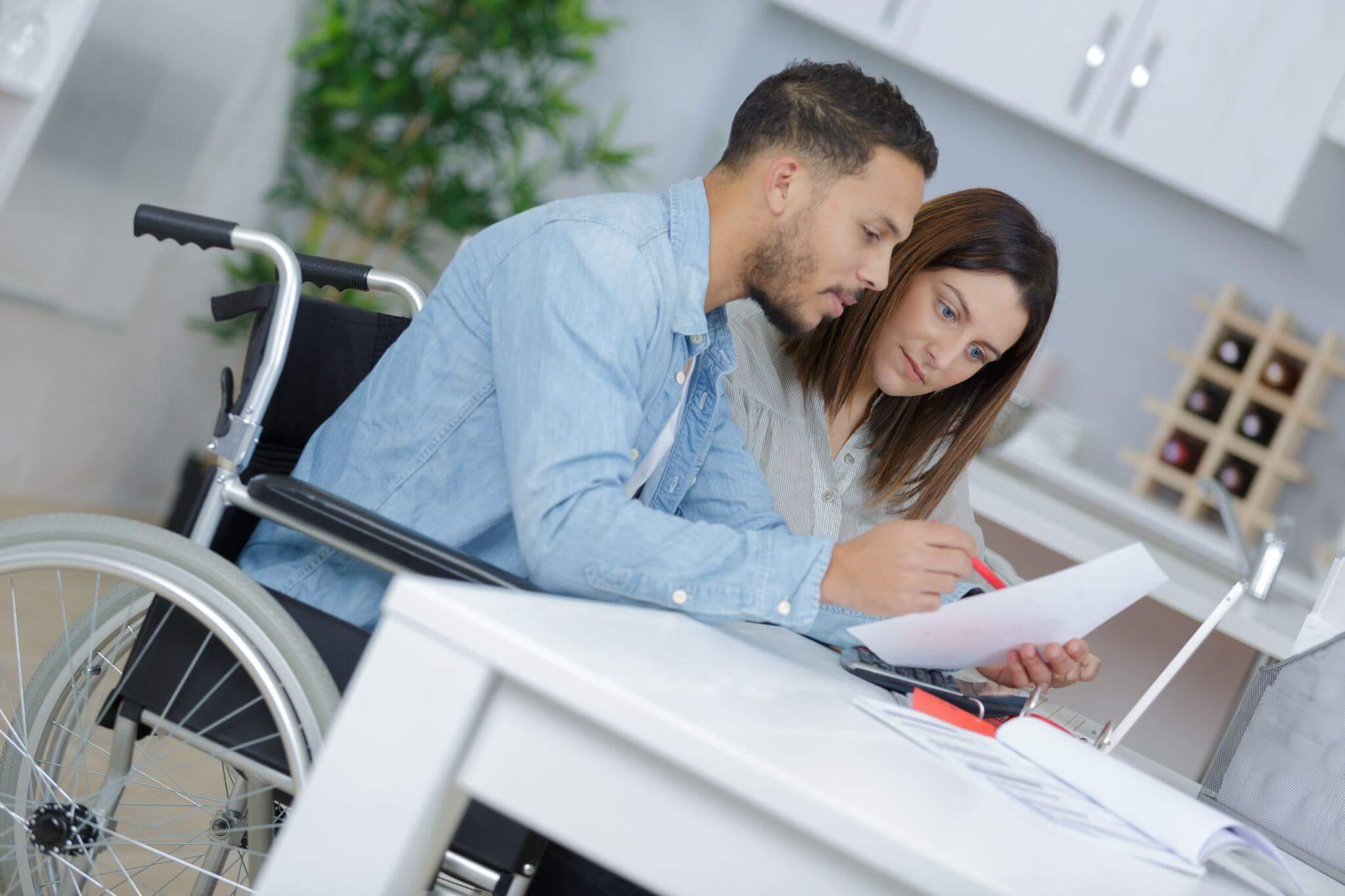 a man in a wheelchair and a woman in a kitchen