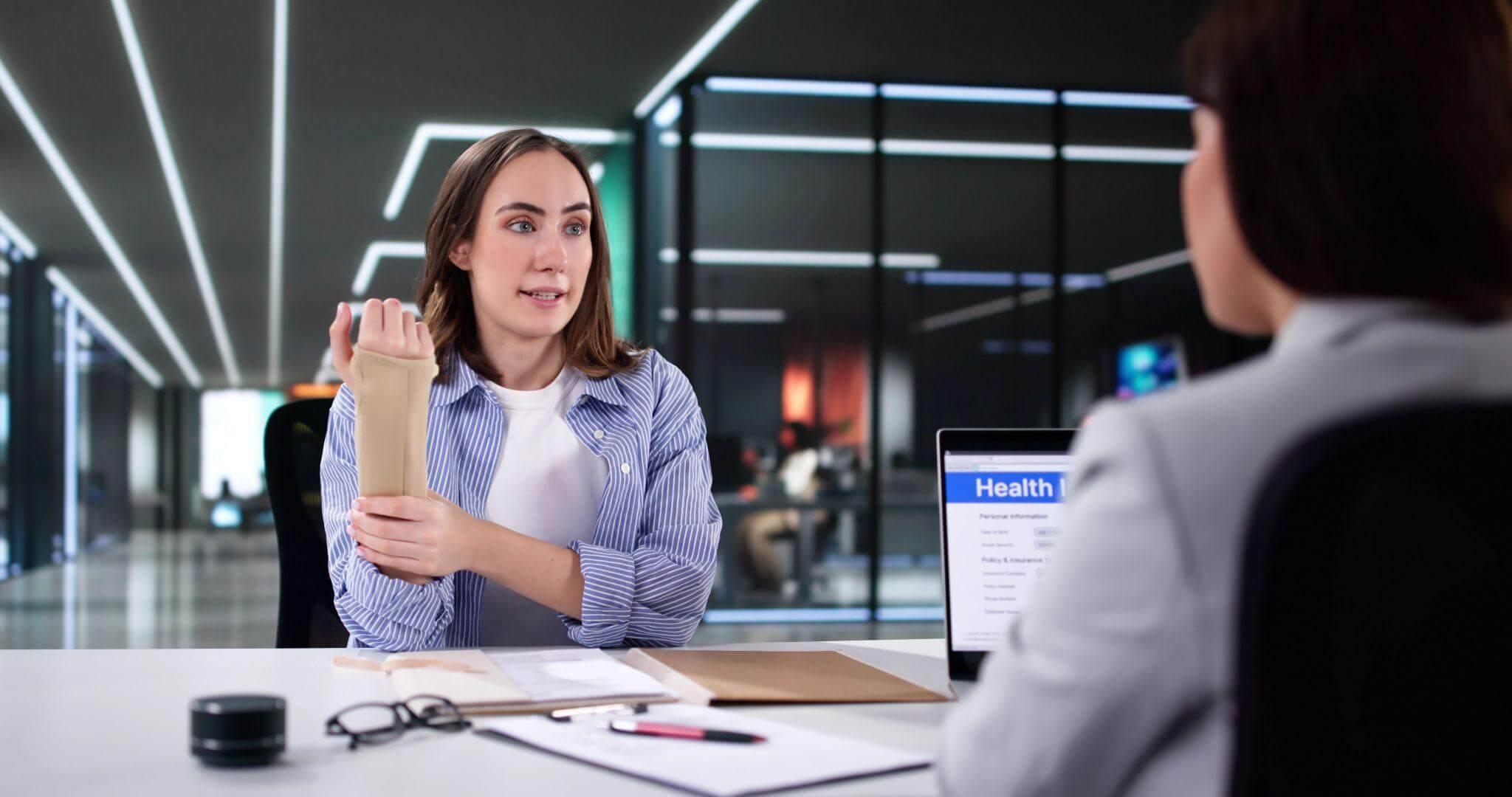 Woman reviewing documents at desk for insurance claim