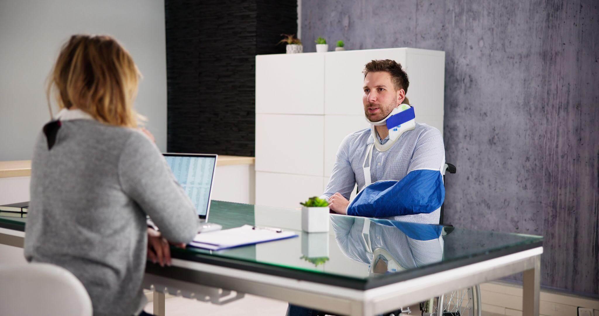 a man with a cast on his arm sitting at a desk