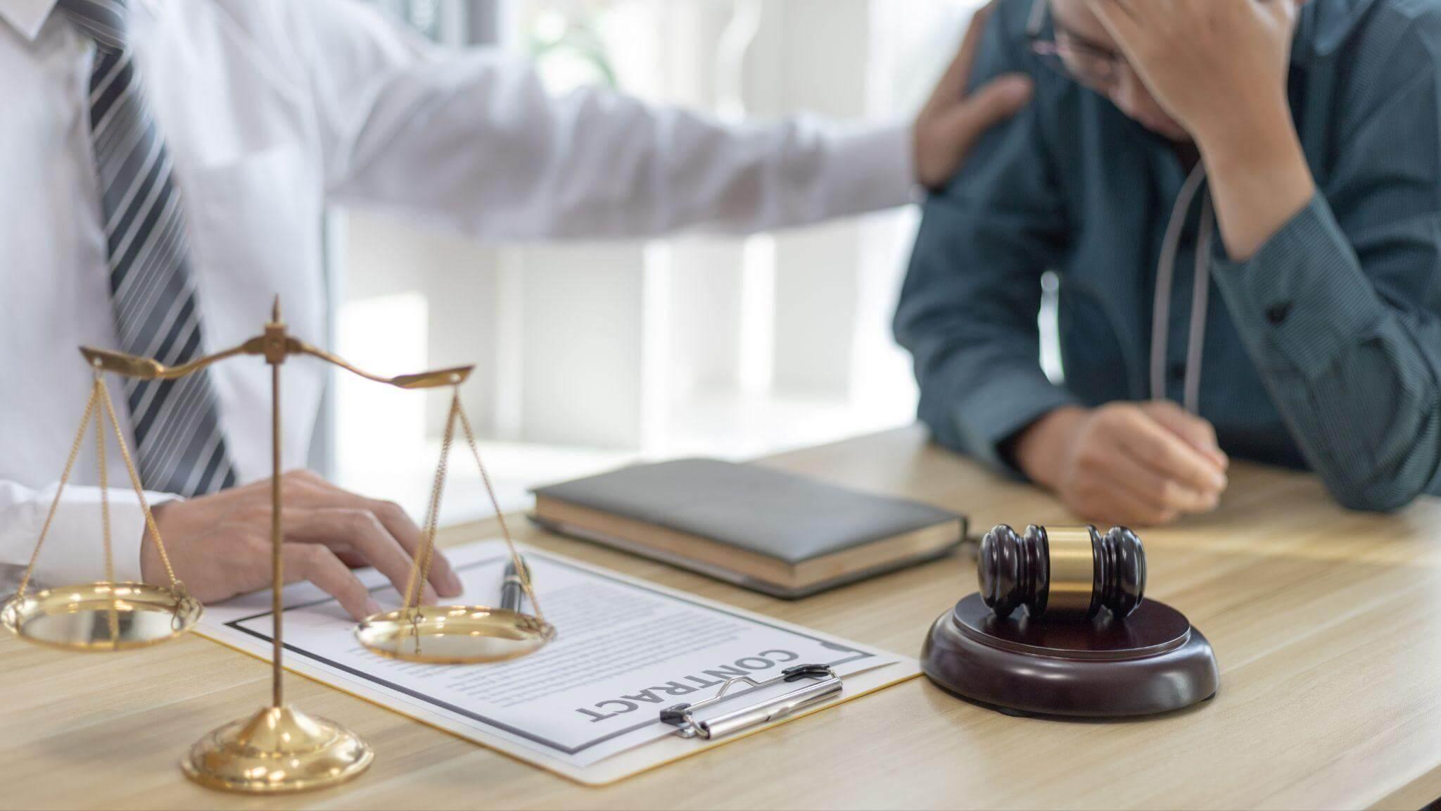 a man sitting at a table with a scale of justice on it