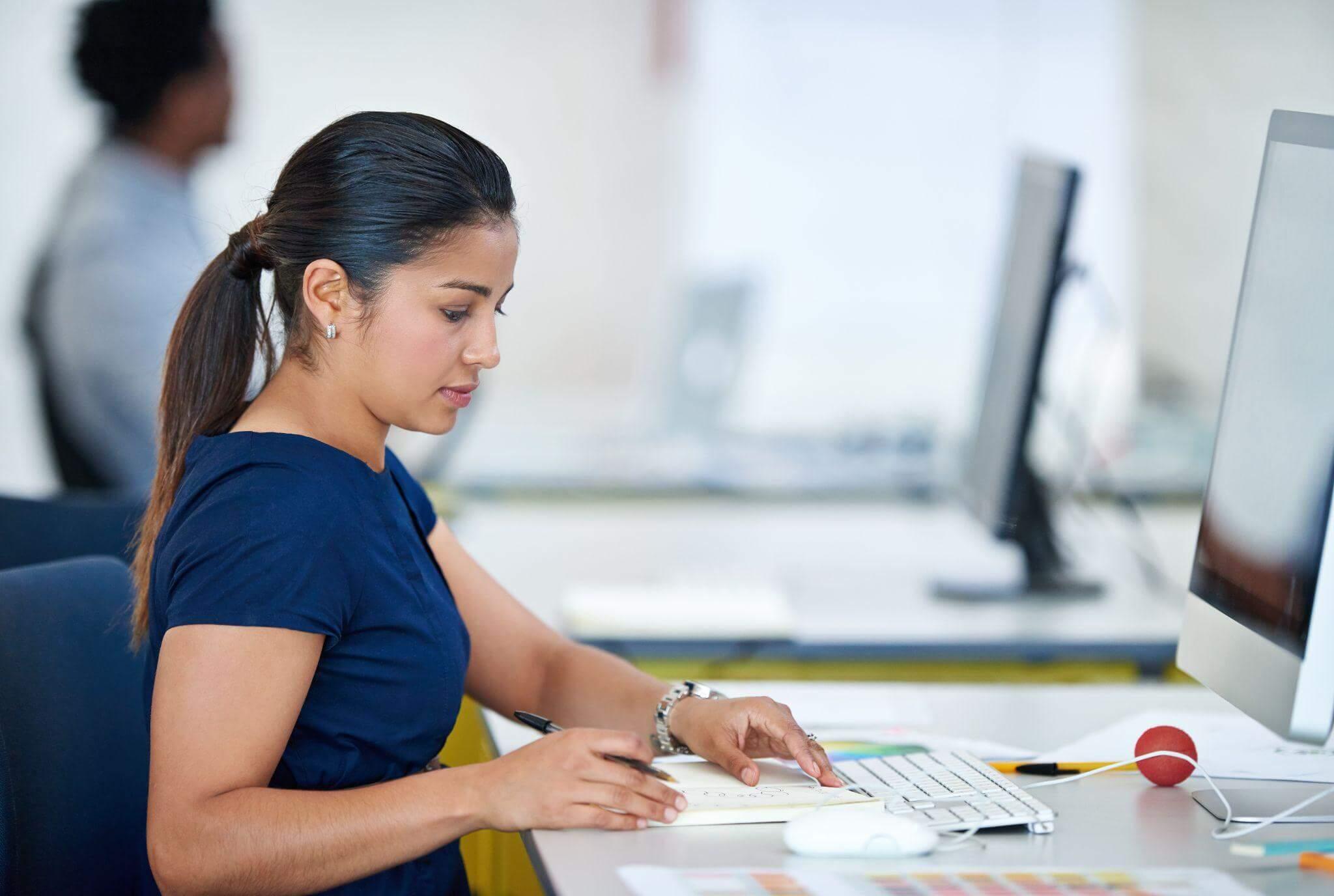 a woman sitting at a desk working on a computer