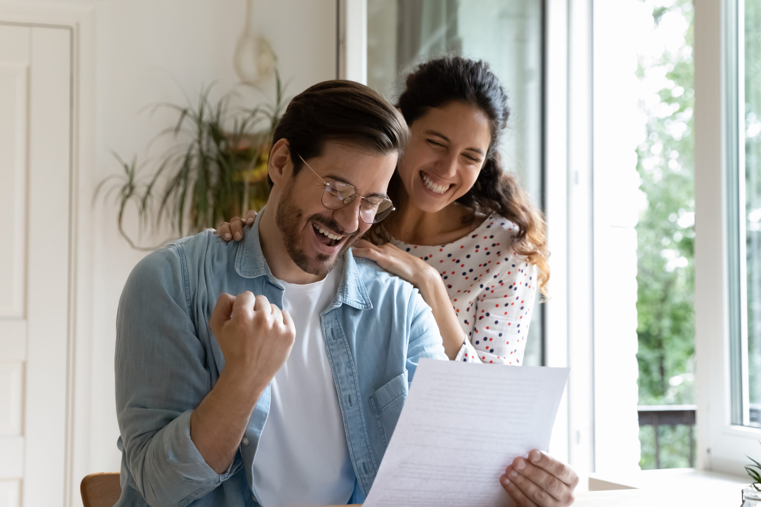 husband and wife celebrating insurance claim compensation letter