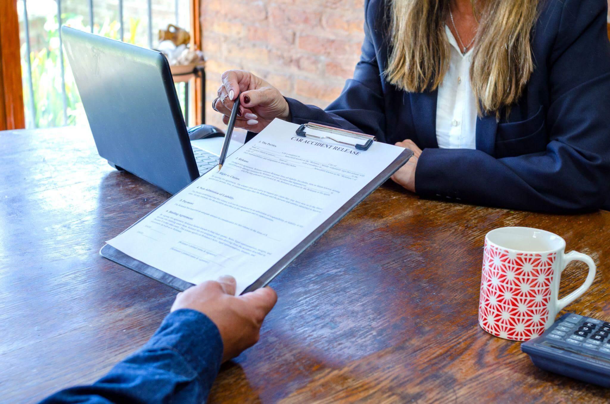 a woman sitting at a table signing a document