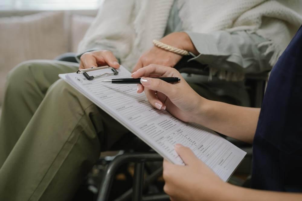 A person in a wheelchair holding a clipboard, representing